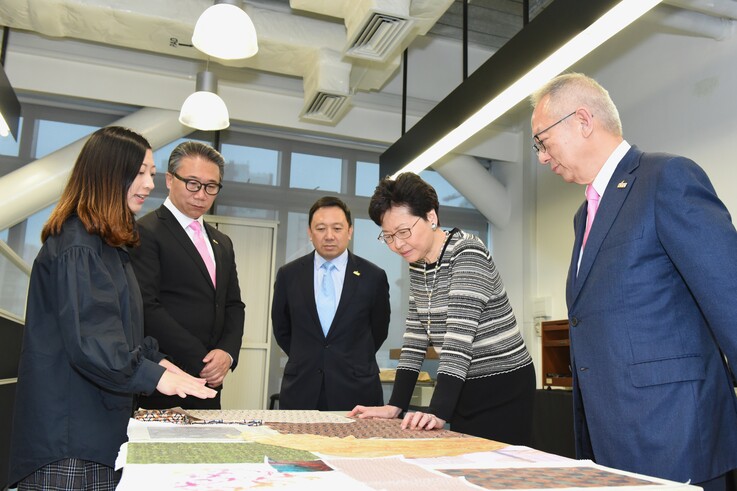 THEI时装设计（荣誉）文学士学生向行政长官林郑月娥（右二）分享运用数码纺织打印技术设计创意作品
